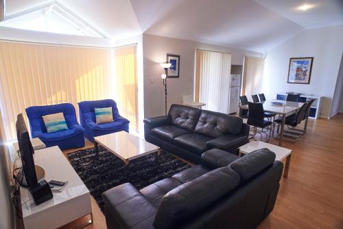 a living room with a couch and chairs and a table at Golf and Beach Retreat in Albany