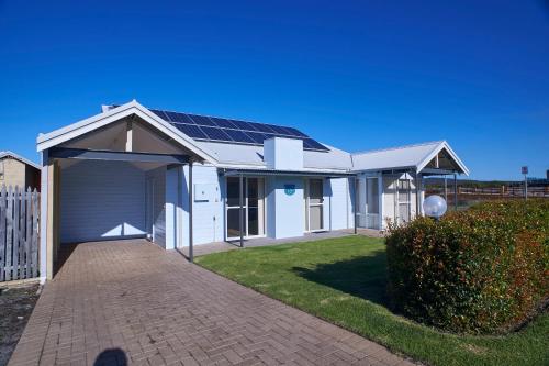 a house with solar panels on the roof at Golf and Beach Retreat in Albany