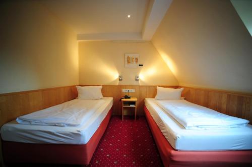 two beds in a small room with a small table at Gasthof Löwen, Heitersheim in Heitersheim