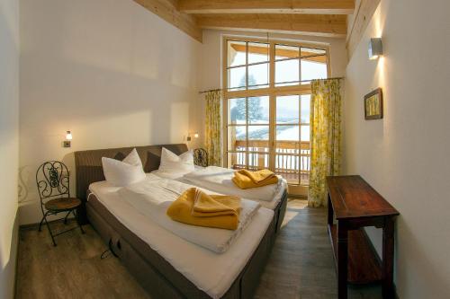 a bedroom with a bed with two yellow towels on it at Landhaus Bergglühen in Oberjoch