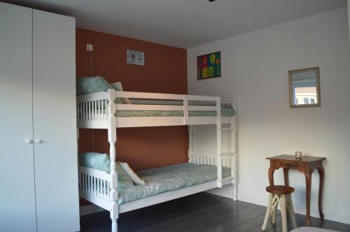 two bunk beds in a room with a table at Casa Camino in Bruges