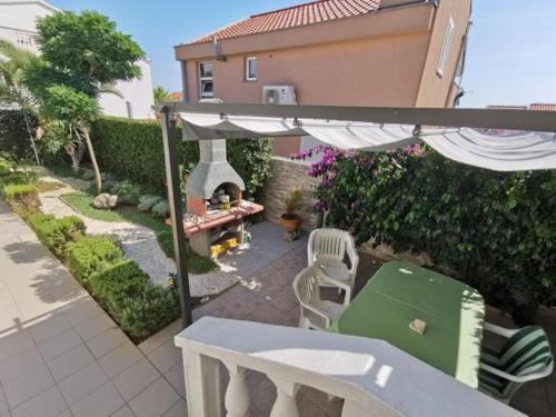 een uitzicht over de achtertuin met een parasol en een tafel bij Studio apartman MARIJA in Petrcane