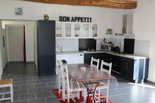 a kitchen with a table and chairs in it at Le Gite de l'Etrier in Canchy