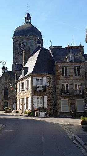 an old brick building with a clock tower on top at Cosy Er Lann Chambres d'Hôtes in Val Couesnon