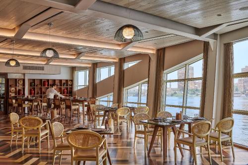 a dining room with tables and chairs and windows at Four Seasons Cairo At The First Residence in Cairo