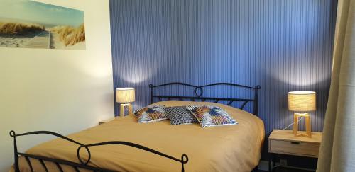 a bedroom with a bed with two pillows on it at Cosy Er Lann Gîte Cèdre in Val Couesnon