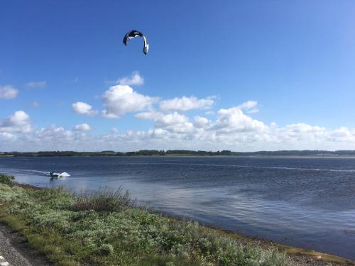 a person is kite surfing on a body of water at Aa Strand Camping in Ebberup