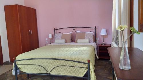 a bedroom with a large bed with pink walls at Lina A & M in Neo Klima