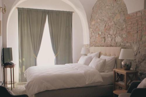 a bedroom with a large white bed and windows at May House Rodinný Historický dom in Modra