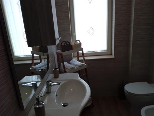 uma casa de banho com um lavatório, um WC e um espelho. em Casa Vanna em Torre del Greco