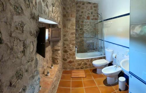 a stone bathroom with a toilet and a sink at Castillo con piscina en plena Sierra Calderona in Segorbe