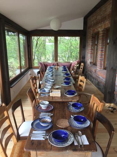 a long wooden table with blue and white dishes on it at Lipowy dom in Piecki