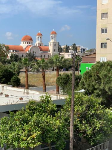 Blick auf eine Stadt mit Palmen und ein Gebäude in der Unterkunft Tony’s Boutique Apartment in Larnaka