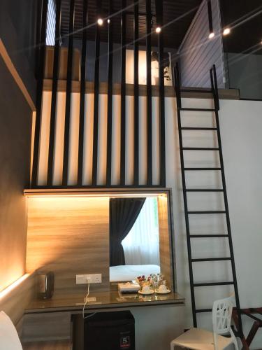 a loft bed with a mirror in a room at The Corner House in Pontian Kecil