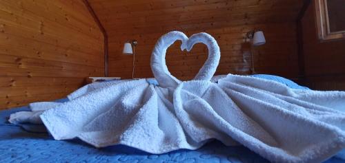 two swans wrapped in a white blanket on a bed at Belvedere La Cristina in Corbeni