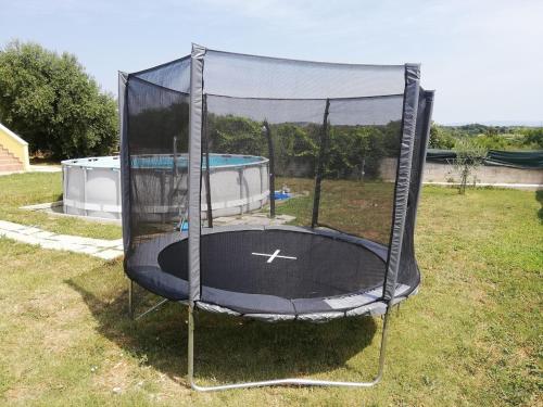 a trampoline in a yard with a pool at Apartment Stanko in Ližnjan