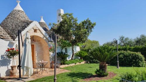 a garden with an umbrella and a house at B&B Tenuta Ranieri in Selva di Fasano