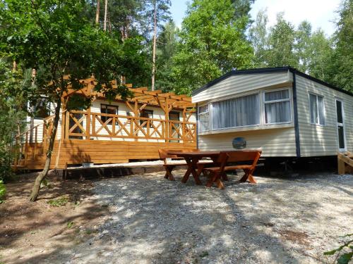 a cabin with a picnic table and a trailer at Domki nad Wartą in Wierzchlas