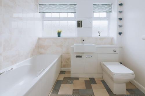 un bagno con vasca, WC e lavandino di Inner Harbour Cottage a Portreath