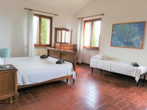 a bedroom with two beds and a dresser and windows at Villa Lavanda in San Venanzo