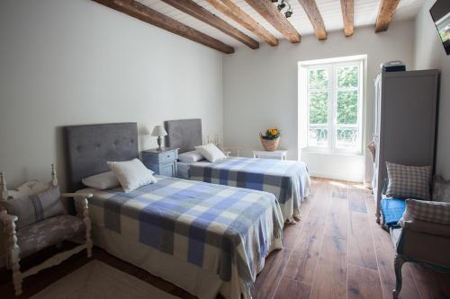 a bedroom with two beds and a chair and a window at Posada Seis Leguas in Ríocorvo