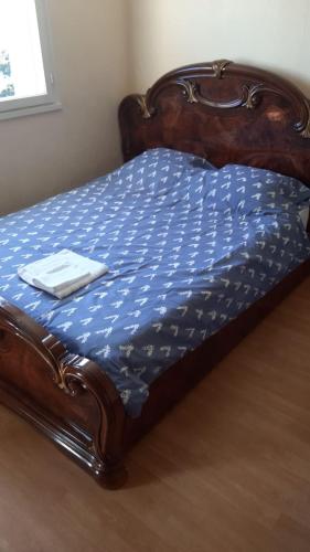 a bed with a blue comforter with a wooden frame at Résidence Commandant Champigny in Angers