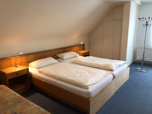 a bedroom with a bed with two pillows on it at Hotel Cao in Hemmingen