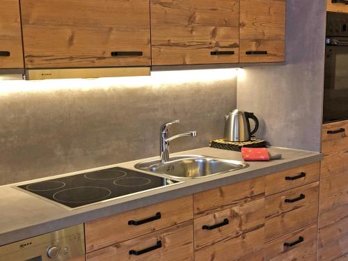 a kitchen with a sink and a stove at Pircher-Maes Apart & Stubaital in Telfes im Stubai