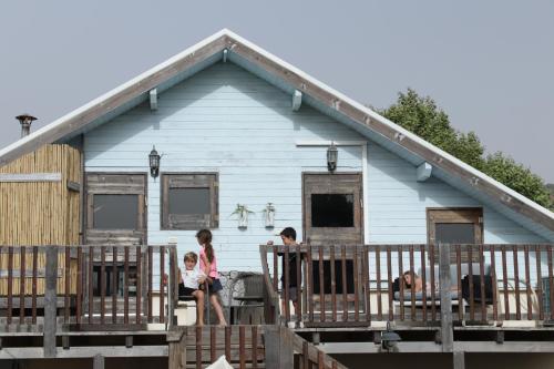 a group of children sitting on the porch of a house at Healing Hands in Merom Golan