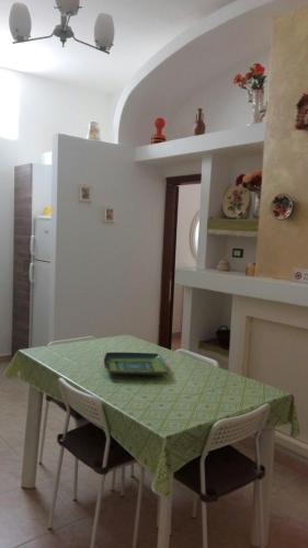 a kitchen with a table with a green table cloth on it at villa Beatrice in Serranova