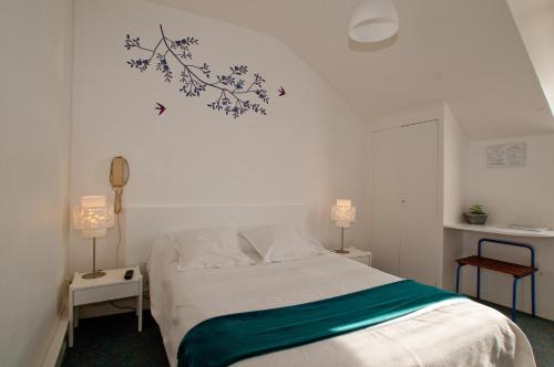 1 dormitorio con 1 cama blanca y 2 lámparas en hotel de la plage, en Piriac-sur-Mer