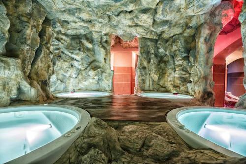 Grand Hotel Vigna Nocelli في لوتشرا: حمام مع ثلاثة أحواض في كهف حجري