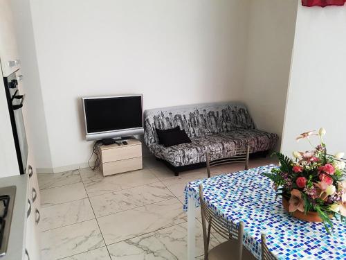 sala de estar con sofá y TV en Villa Sandra, en Cesenatico