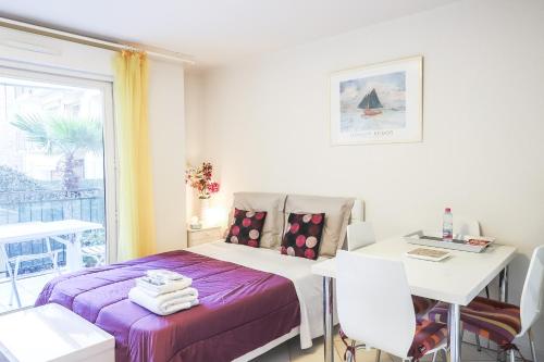een slaapkamer met een bed, een tafel en een raam bij CANNES Palazzio in Cannes