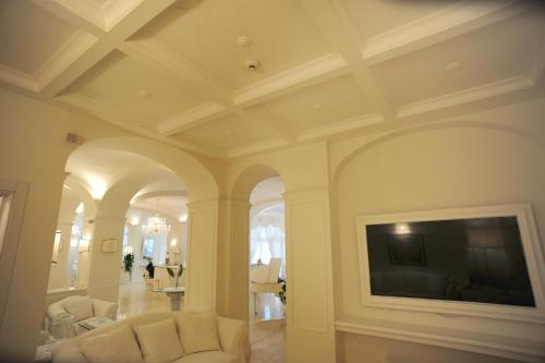 a living room with white furniture and a flat screen tv at Minori Palace in Minori