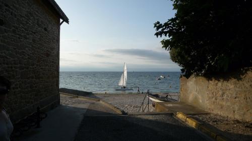 a sail boat in the ocean with a sail boat in the water at hotel de la plage in Piriac-sur-Mer