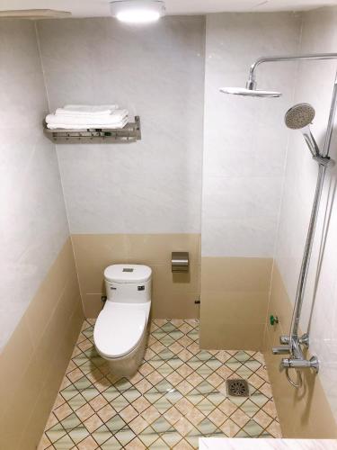 un baño con inodoro y ducha en Gia Quý Hotel, en Cao Bằng