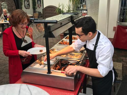 a man and a woman preparing food in a kitchen at Hotel Krupp in Bad Neuenahr-Ahrweiler