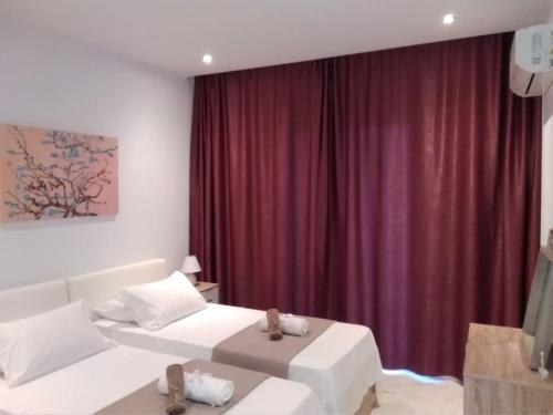 a bedroom with two beds and a red curtain at Sea La Vie Apt. in Paleokastritsa