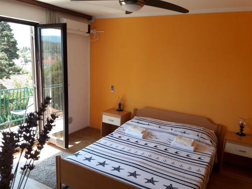 a bedroom with a bed and a balcony at Villa Welcome in Vrboska