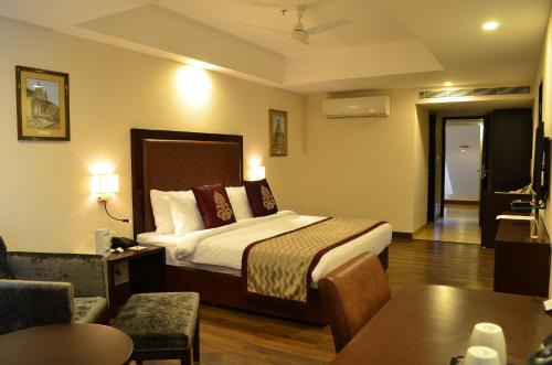 Habitación de hotel con cama y sala de estar. en The Cloud Hotel, en Ahmedabad
