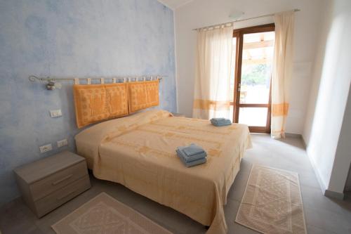 um quarto com uma cama com duas toalhas em Su Suberju em San Teodoro