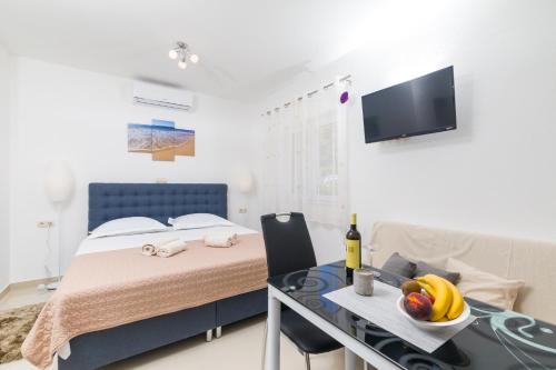 a bedroom with a bed and a table with fruit on it at Guest House Marinna in Vrboska