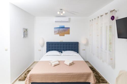 a bedroom with a blue bed with towels on it at Guest House Marinna in Vrboska