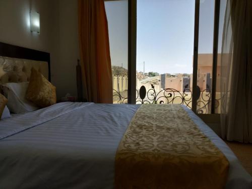 Schlafzimmer mit einem großen weißen Bett und einem Balkon in der Unterkunft Al Wadi Touristic Resort in Al Shafa