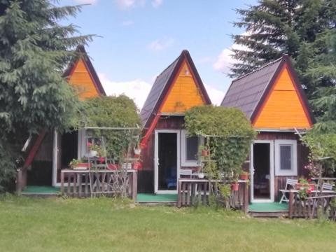 a small house with an orange roof and a yard at casa paltin vila si cabane in Poiana Stampei