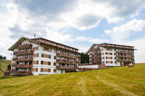 deux bâtiments au sommet d'une colline herbeuse dans l'établissement MJ Apartments Panorama, à Donovaly