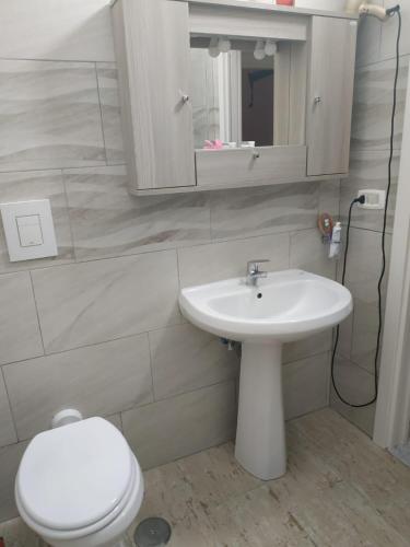 a bathroom with a sink and a toilet and a mirror at TO & GI in Striano