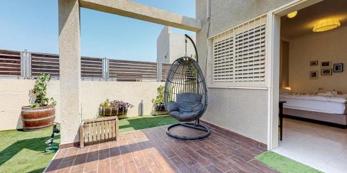 a bird cage sitting on top of a patio at Rom HaTayelet in Arad