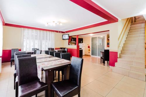 a dining room with a long table and black chairs at Pensiunea Dorali in Moieciu de Jos